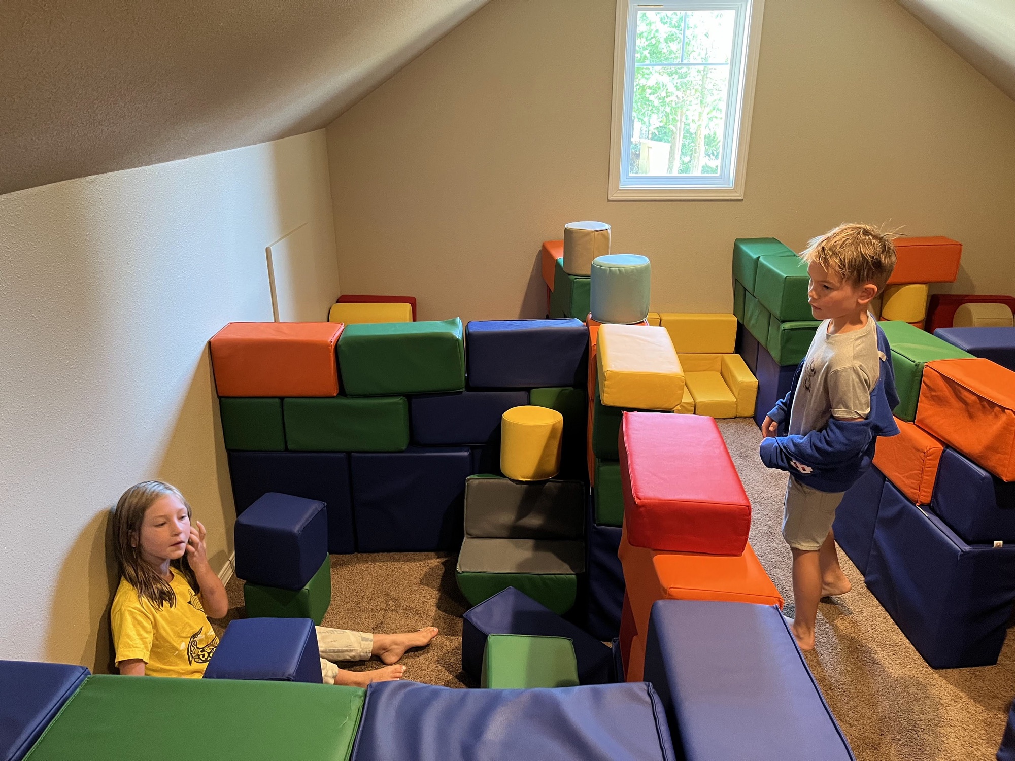 Two kids in a soft-block fort